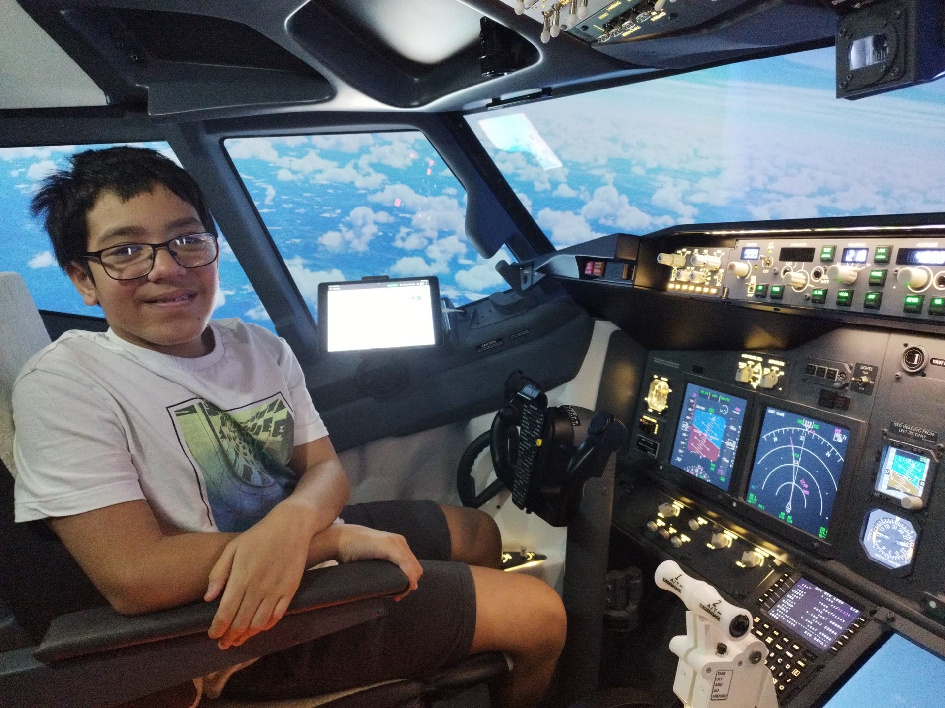 Young guest smiling in the left seat, blue sky and clouds filling the panoramic windshield ahead
