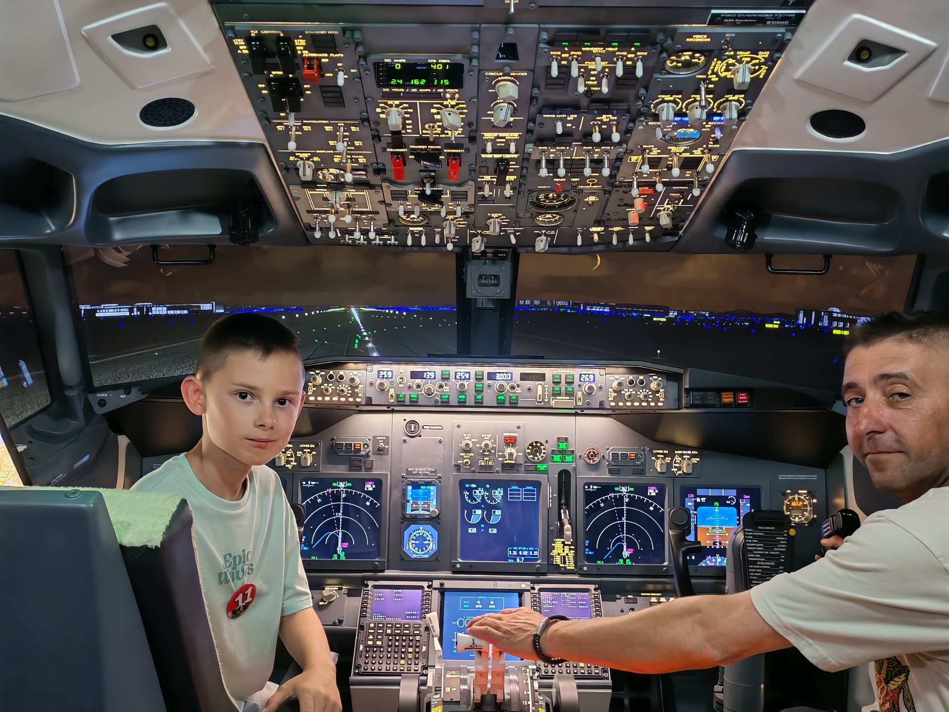Instructor and young guest at the controls, the full flight deck framed by the open cockpit door